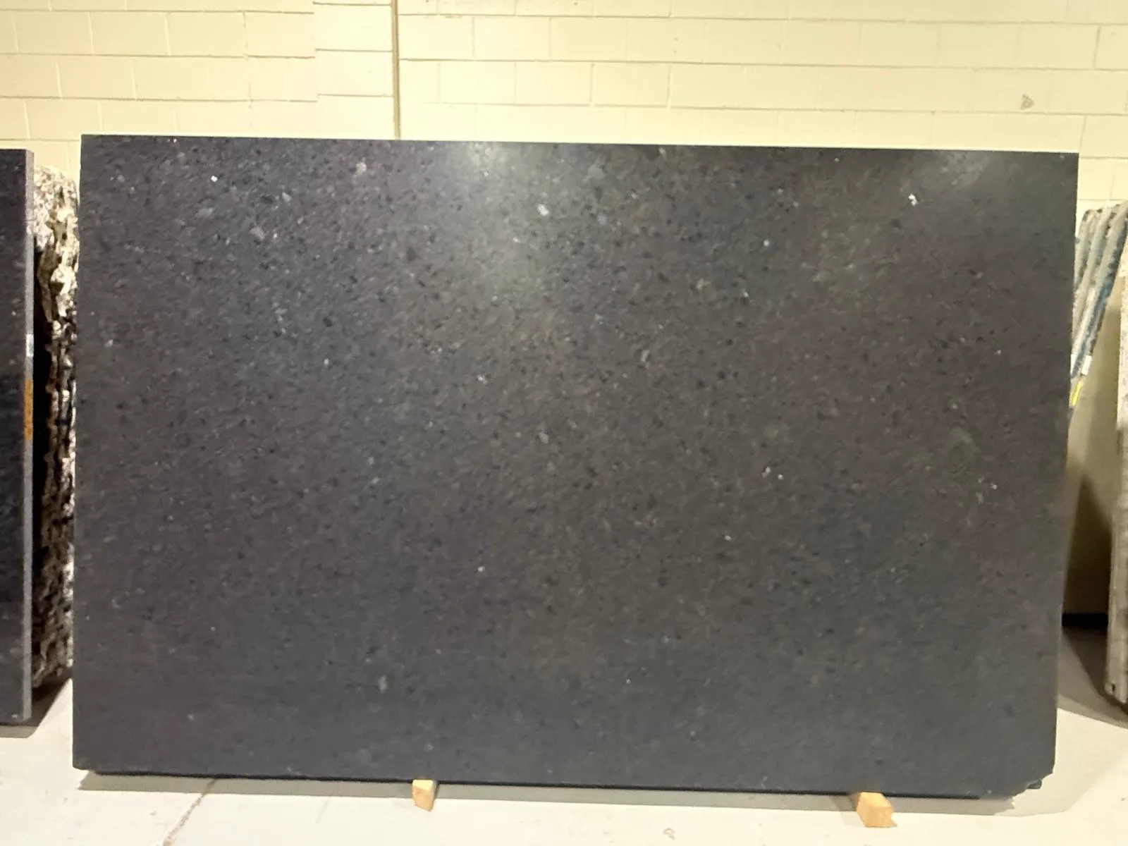 Coffee Brown granite slab, deep espresso brown-black with fine mottled grain, at StoneX USA West Allis