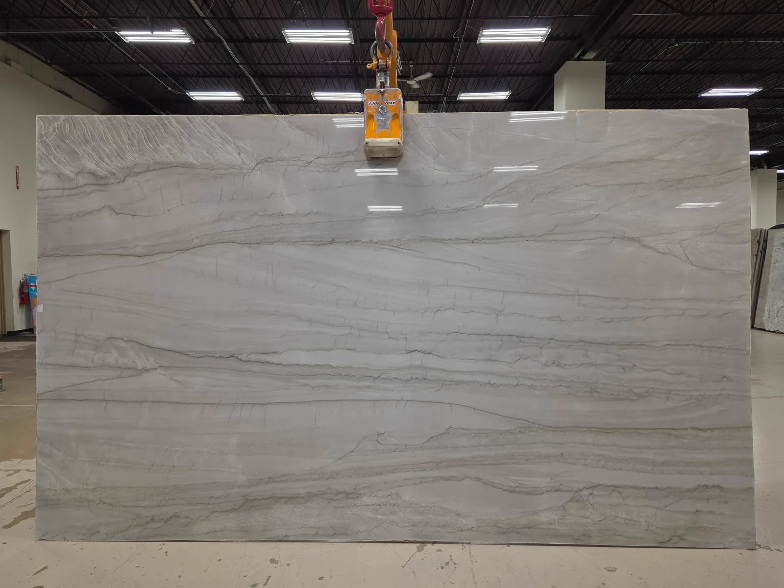 Matarazzo polished dolomite quartzite slab with flowing taupe-grey horizontal veins on a pearl-grey ground